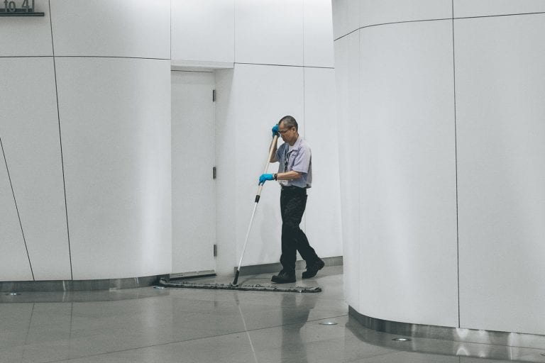 Man cleaning white wall